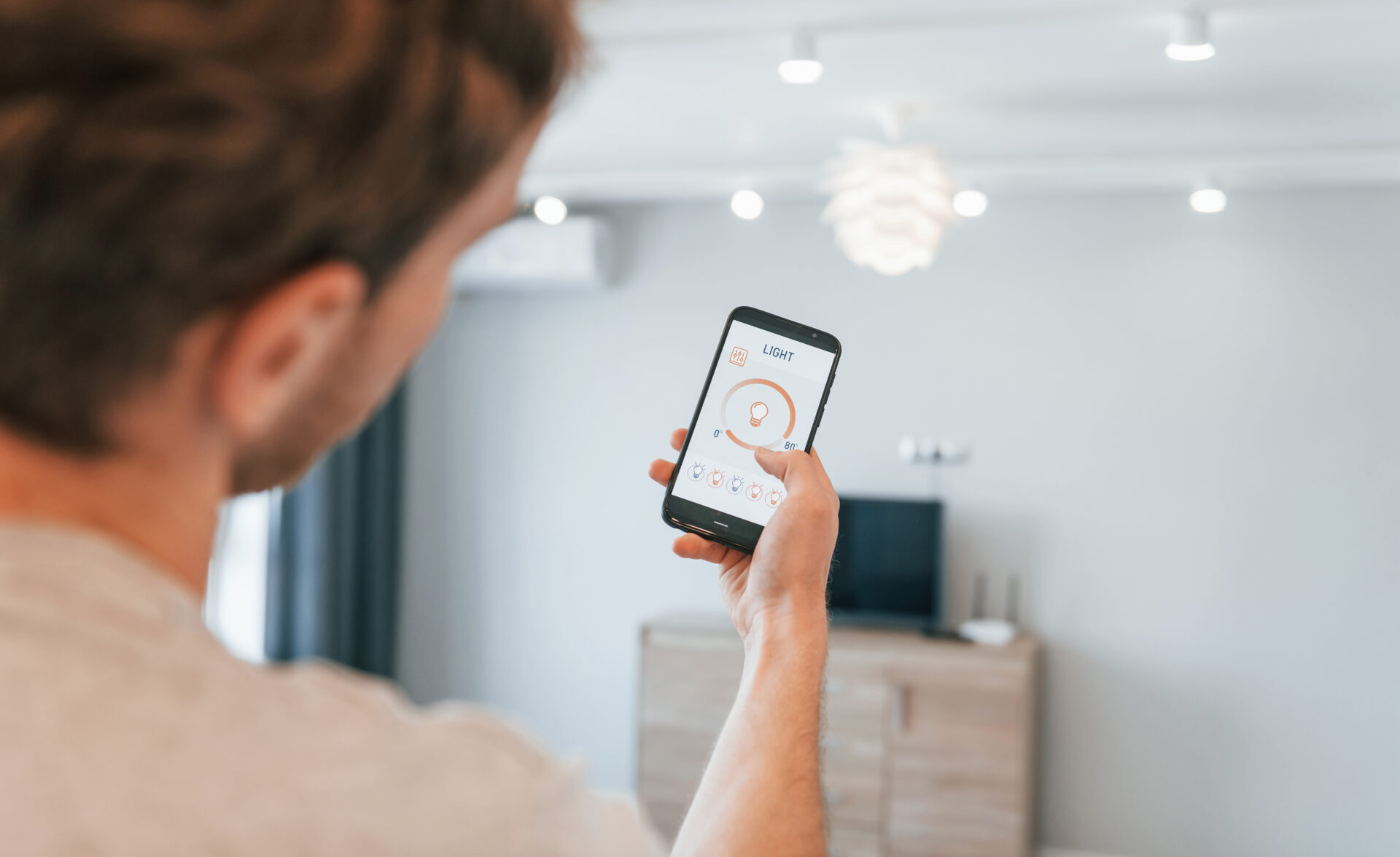A homeowner using a smartphone app to control smart home devices.