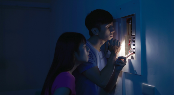 A man and a women inspecting their circuit breaker panel